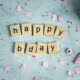 Titelbild Geburtstagswünsche GESCHENKMAMSELL: Moodbild mit Happy Birthday aus Holzscrabblesteinen