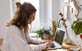 Junge Frau am Laptop. Vielleicht testet sie KI in der Kreativbranche.