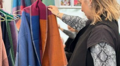 Junge Frau betrachtet Schaljacke, in der Hoffnung, eine Geschenkidee zu finden.