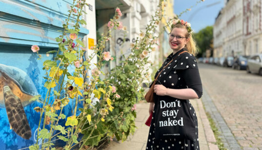 Carolin Otto mit schwarzem „Don't stay naked“-Jutebeutel stöbert während der Hamburg-Tour in einem kleinen Laden in Ottensen.