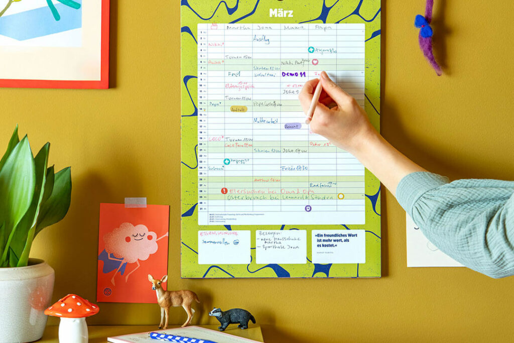 Familienkalender 2027 von Ein guter Plan an einer gelben Wand beim Eintragen von Terminen