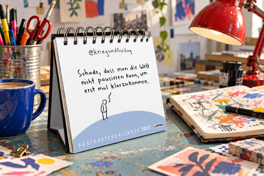 Postkartenkalender 2027 von Krieg und Freitag mit einer Strichmännchen-Zeichnung auf einem bunten Künstlerarbeitsplatz