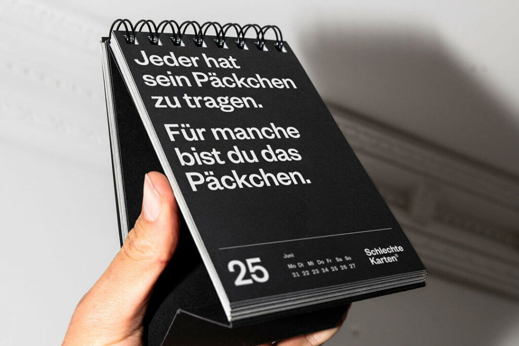 Schwarzer Tischkalender 2027 von Schlechte Karten mit einem sarkastischen Spruch in weißer Schrift.