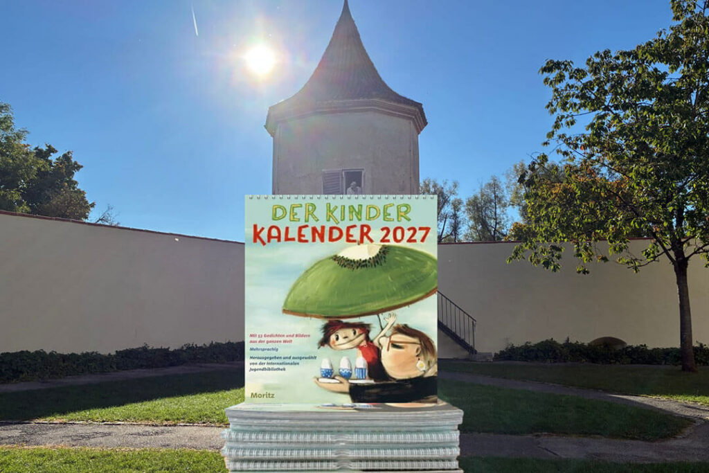 Der Kinder Kalender 2027 aus dem Moritz Verlag, fotografiert vor einem Turm im Freien.