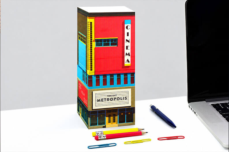 Bunter Hochhaus-Notizblock von Seltmann Publishers auf einem Schreibtisch, daneben Laptop, Stifte und Büroklammern.