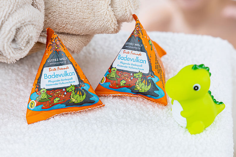 Bunte Gesprächskarten von Finimi liegen neben einem Wasserglas und einer Schale mit Snacks auf einem Tisch.
